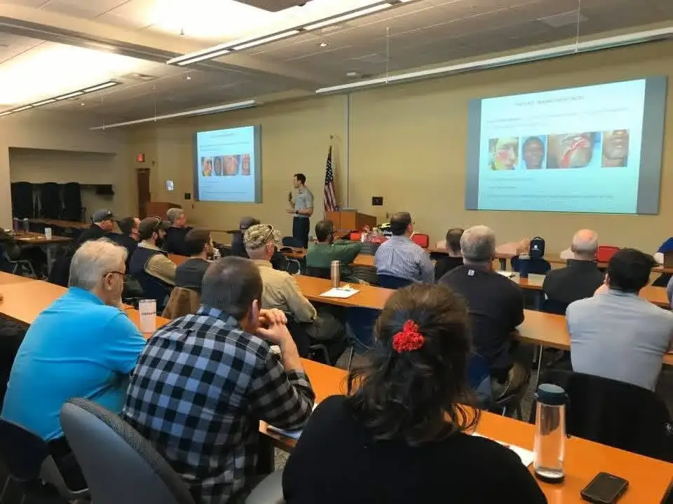 Students attending an instructor-led training session with projected teaching slides.